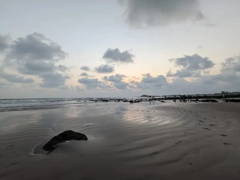 कर्दे समुद्रकिनाऱ्याच्या सपाट वाळूवर ओहोटीच्या वेळी सूर्यास्ताचे शांत प्रतिबिंब